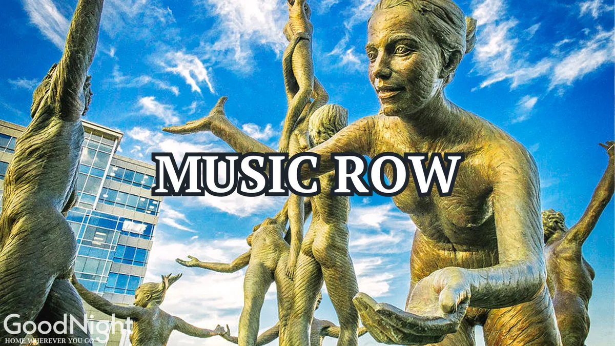 An outdoor plaza featuring striking bronze sculptures against a bright sky, suggesting a lively atmosphere where art, music, and community events converge. The public art installation is front and center, inviting exploration and cultural appreciation.