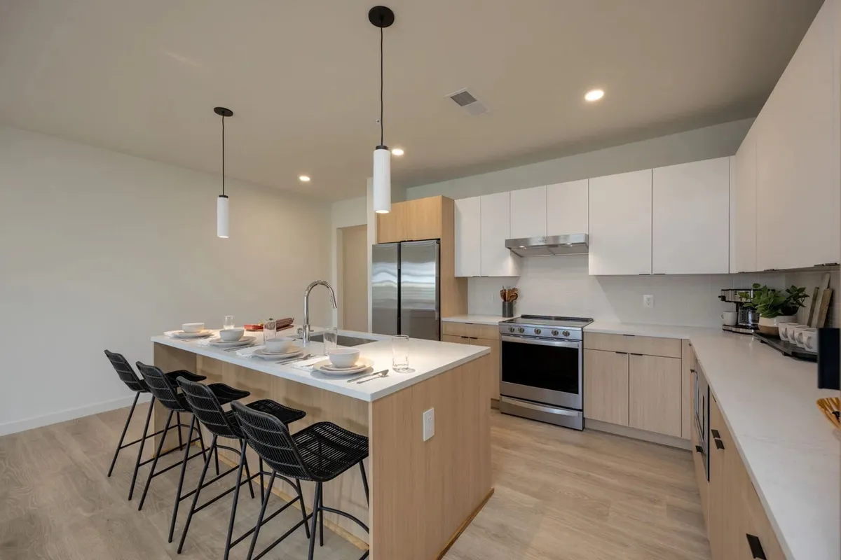 A functional kitchen with a central island, stainless steel appliances, and a dining setup, all designed for both culinary creativity and easy entertaining. The space feels welcoming and practical, well-suited for group breakfasts or holiday celebrations.